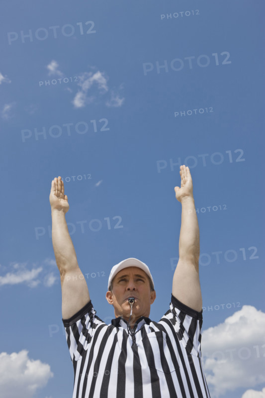 Male football referee making touchdown call.