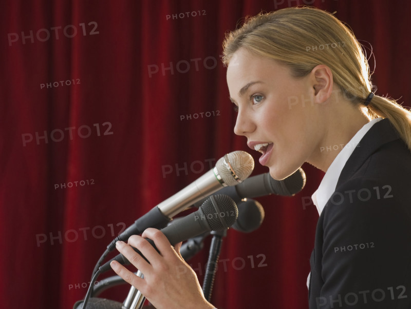 Businesswoman speaking into microphone.