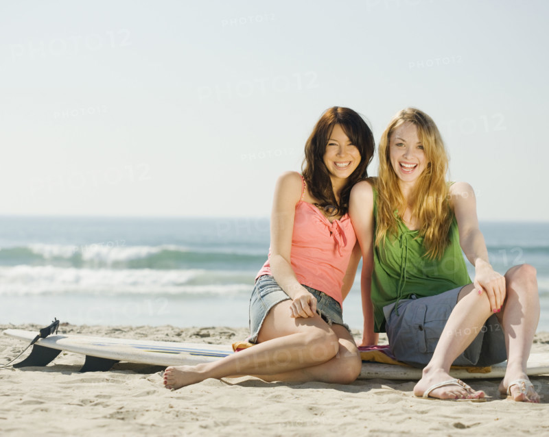 Multi-ethnic women sitting on surf board. Date : 2008