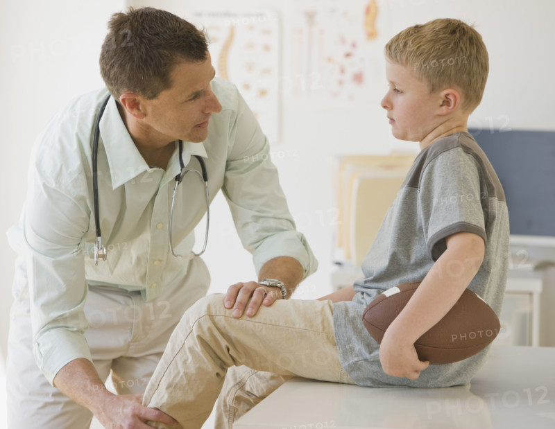 Male doctor examining boy.