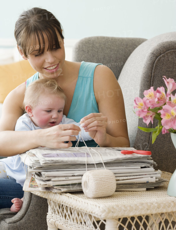 Mother and baby bundling newspapers. Date : 2008