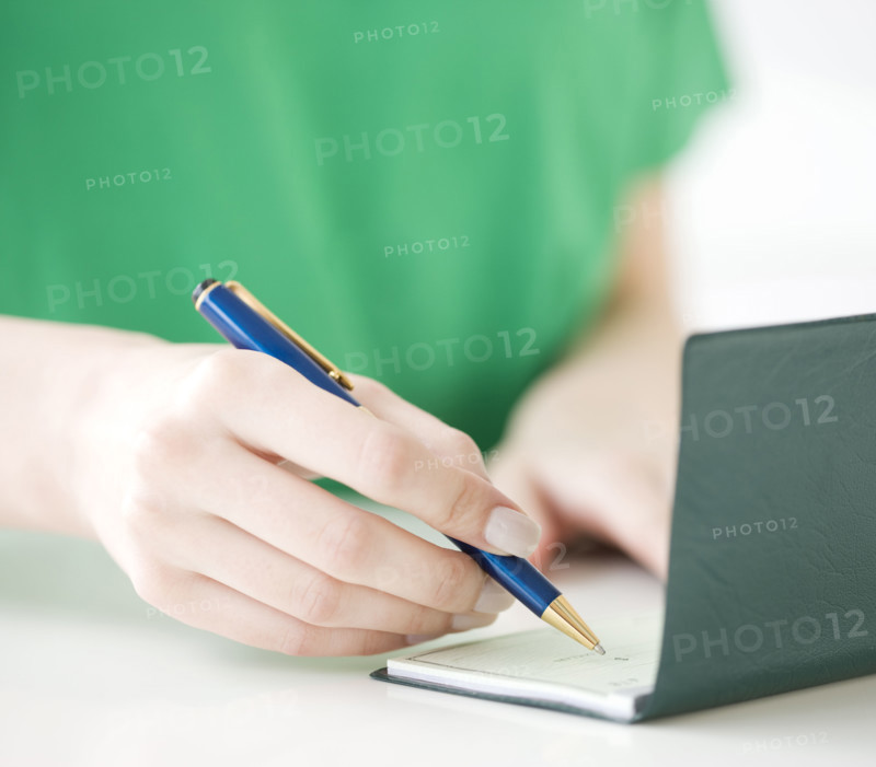 Close up of woman writing check. Date : 2008