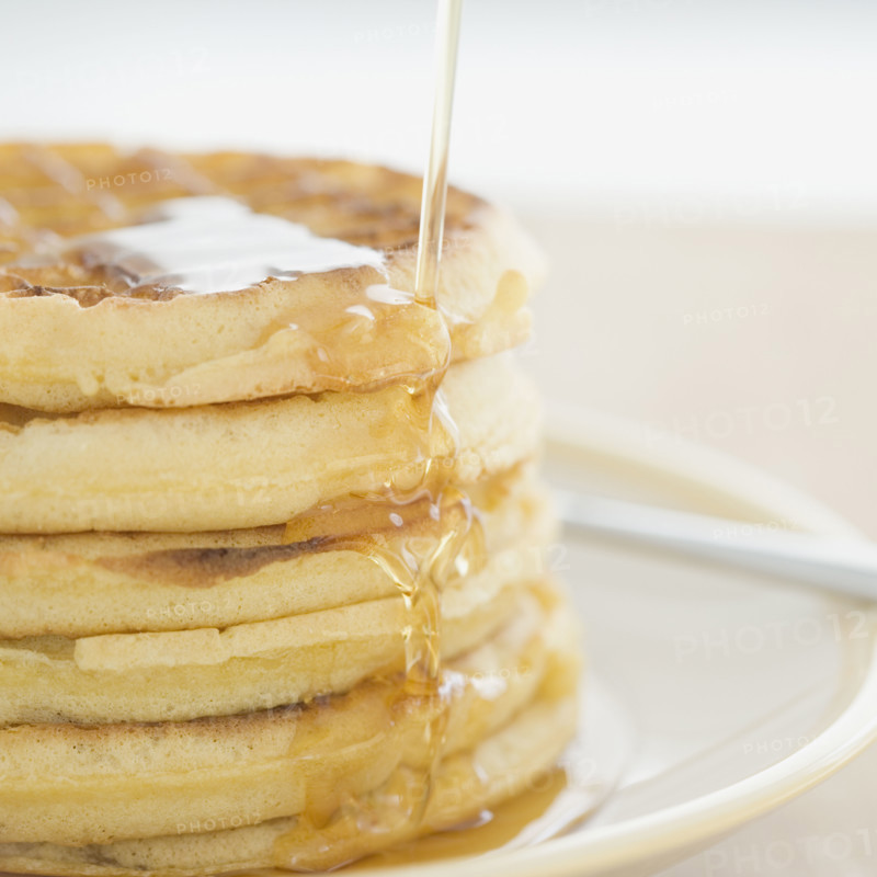 Close up of syrup pouring on waffles. Date : 2008
