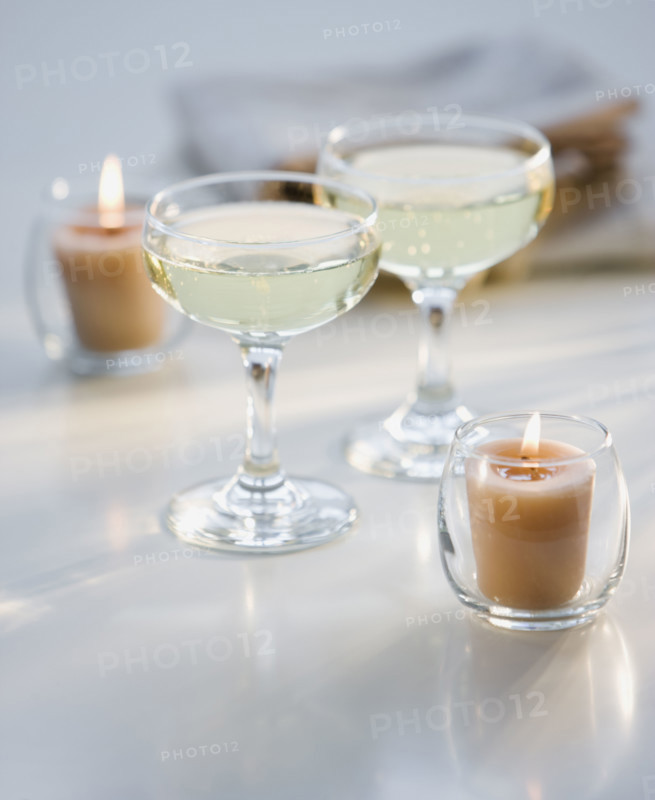 Glasses of champagne next to candles.