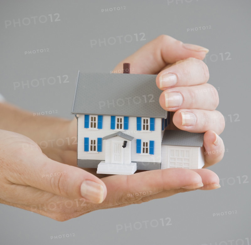 Woman holding model house.