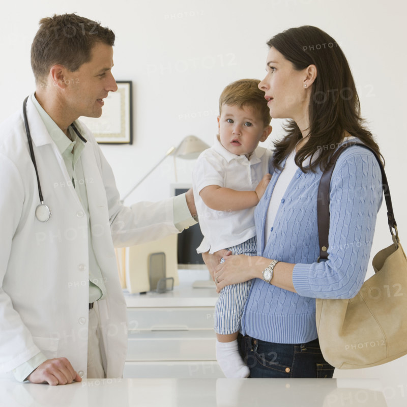 Male doctor talking to mother and son.