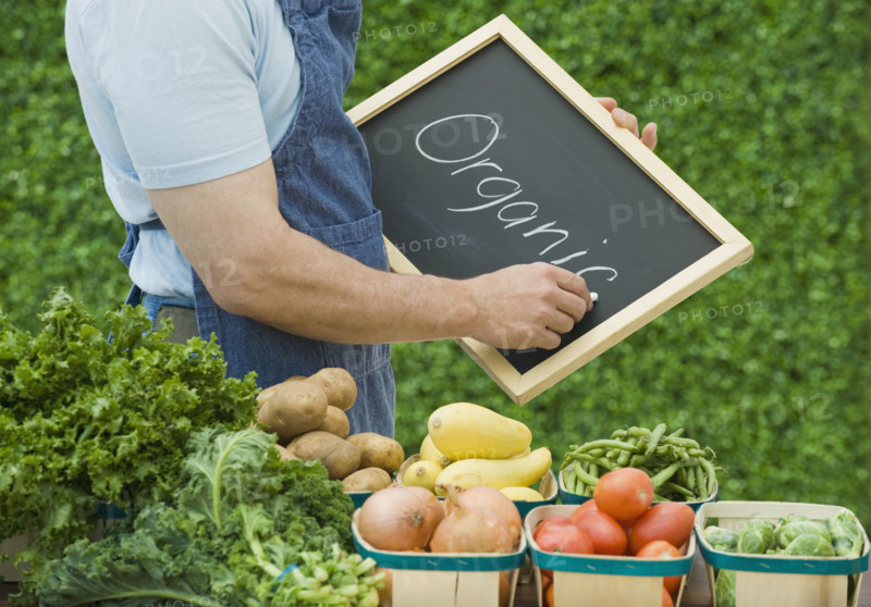 Farmer next to organic vegetables.
