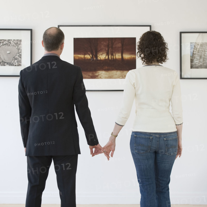 Couple looking at art in art gallery.