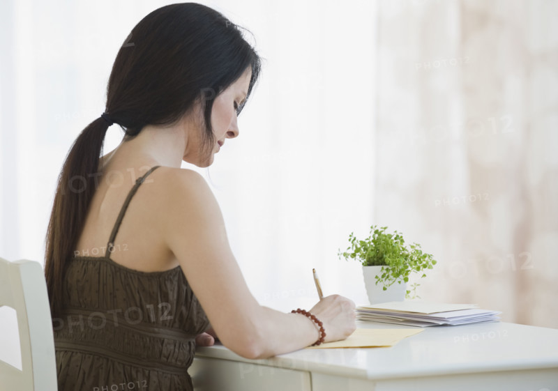 Woman writing at desk.