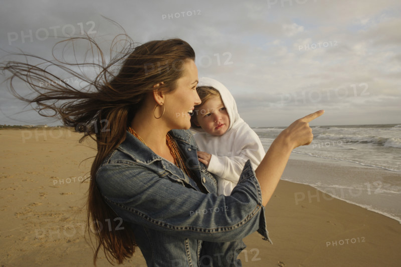 Mother holding baby at beach. Date : 2008