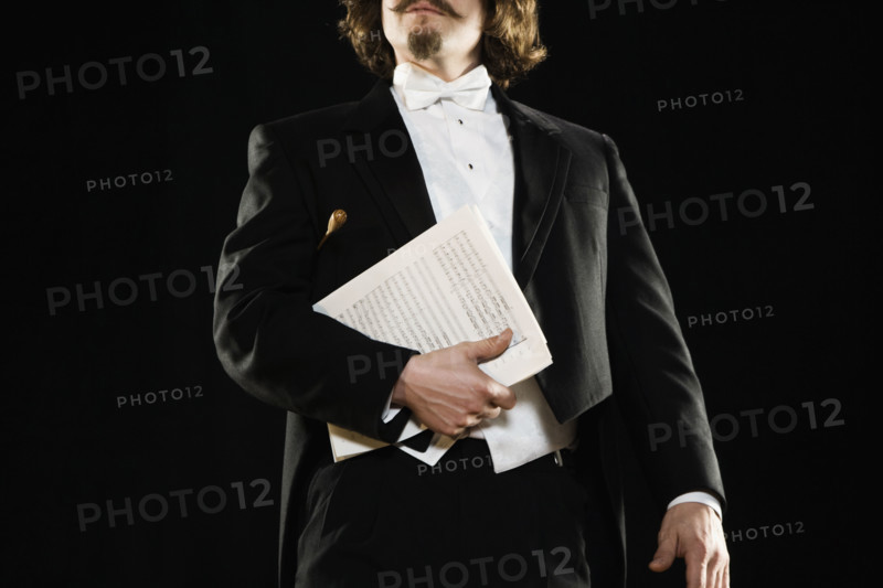 Man in tuxedo holding sheet music. Date : 2008