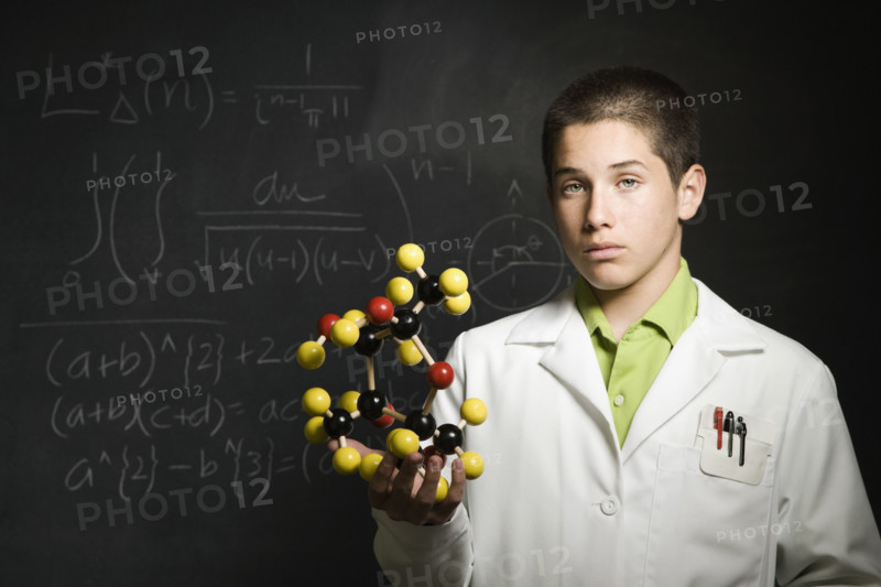 Boy holding molecular model in front of blackboard . Date : 2008