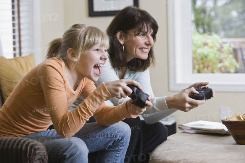 Mother and daughter playing video games. Date : 2008