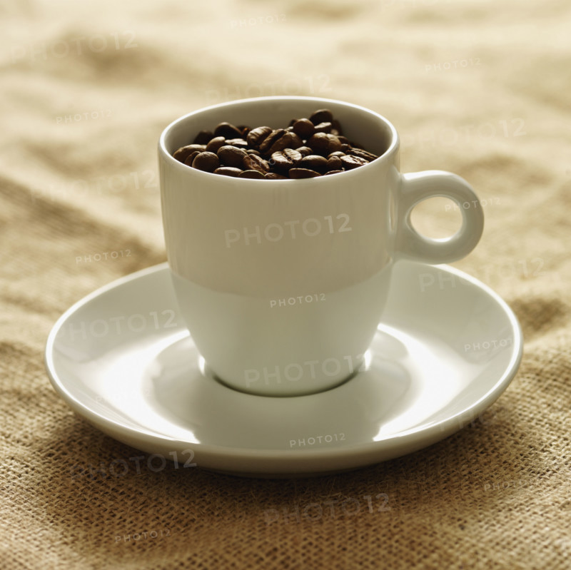 Mug filled with coffee beans. Date : 2008
