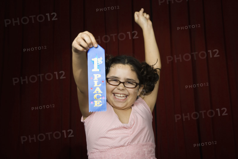 Girl holding first place ribbon on stage. Date : 2008