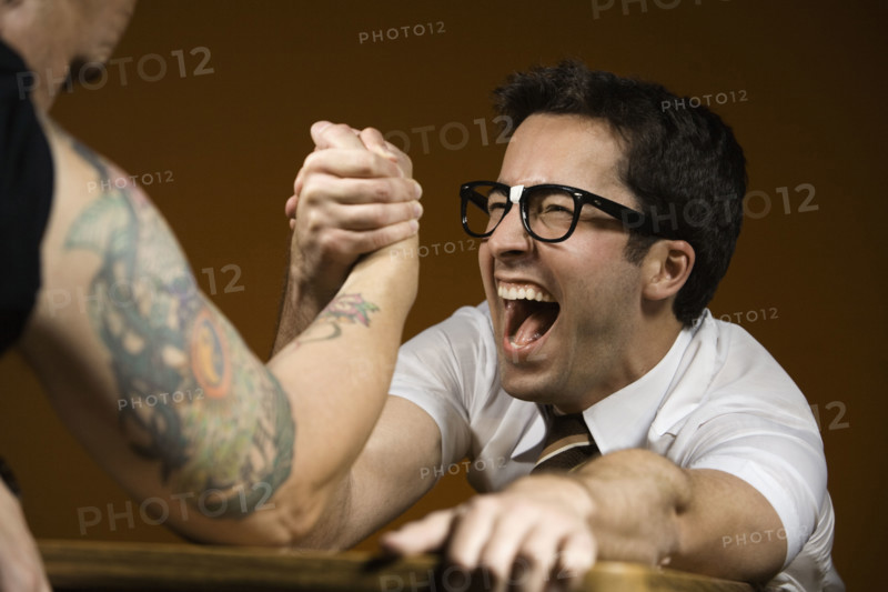 Nerdy man arm wrestling tattooed man. Date : 2008
