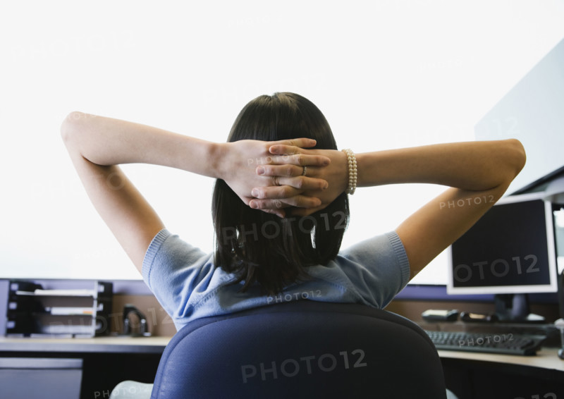 Businesswoman with hands behind head. Date : 2008