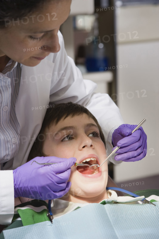 Female dentist examining patient. Date : 2008