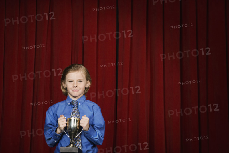 Boy holding trophy on stage. Date : 2008