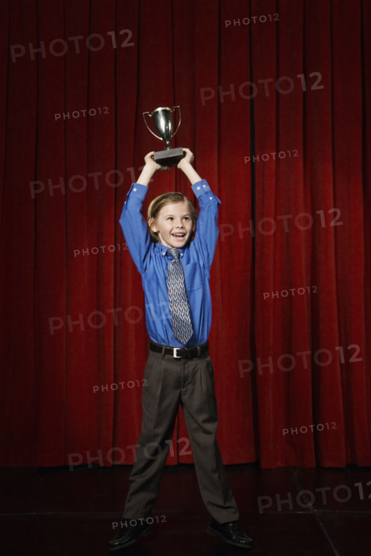 Boy holding trophy on stage. Date : 2008