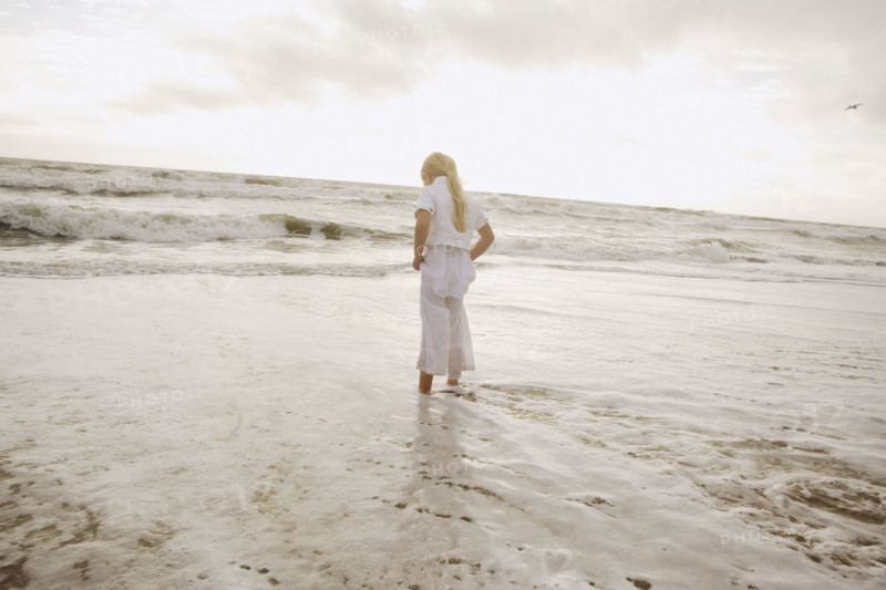 Girl standing in ocean surf. Date : 2008
