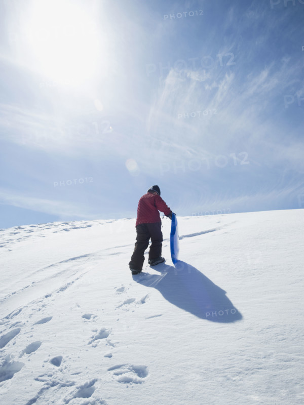 Boy carrying sled in snow. Date : 2008