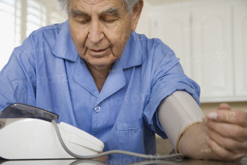 Senior man taking own blood pressure. Date : 2008