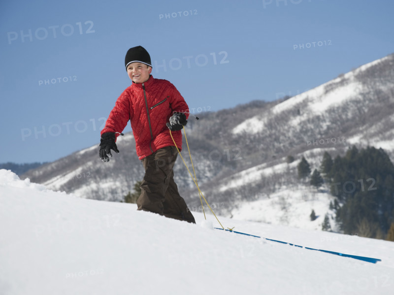 Boy pulling sled in snow. Date : 2008