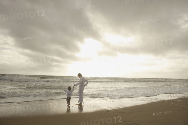 Mother and child holding hands at beach. Date : 2008