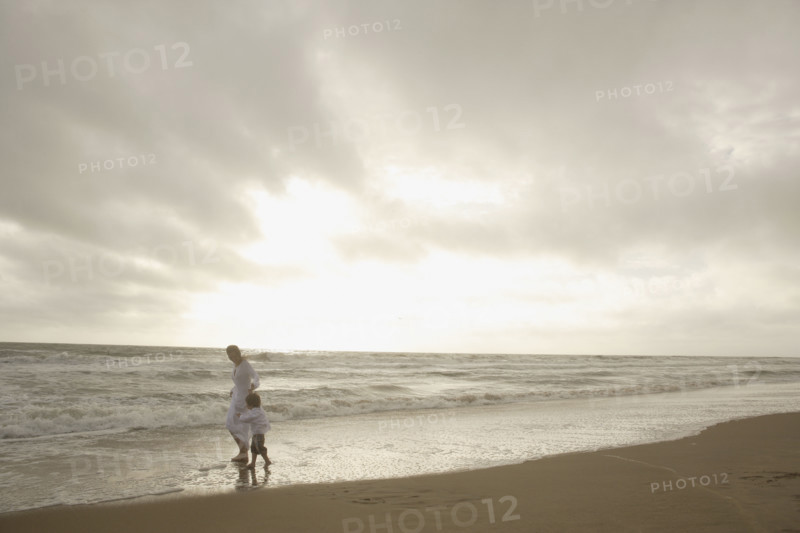 Mother and child walking on beach. Date : 2008