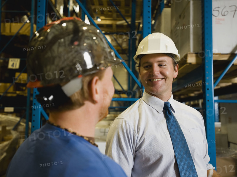 Warehouse workers smiling at each other. Date : 2008