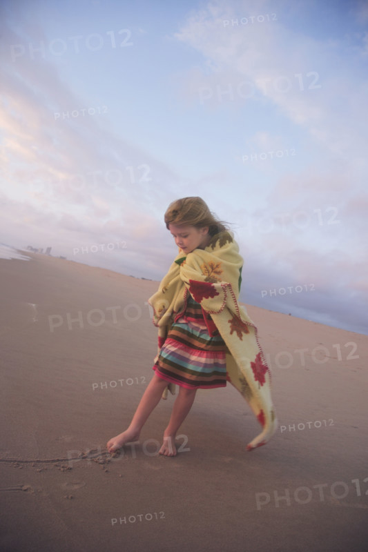 Girl drawing in sand with toe. Date : 2008