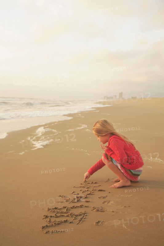 Girl drawing in sand. Date : 2008