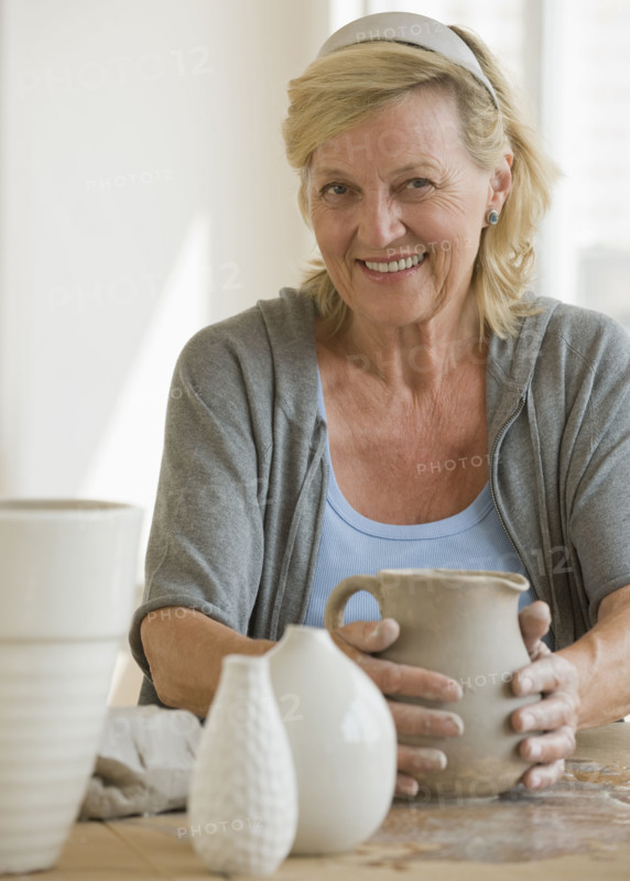 Senior woman making ceramic pots.