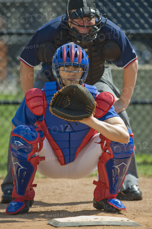 Baseball pitcher and umpire in ready position.