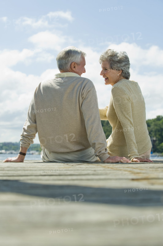 Senior couple sitting on dock.