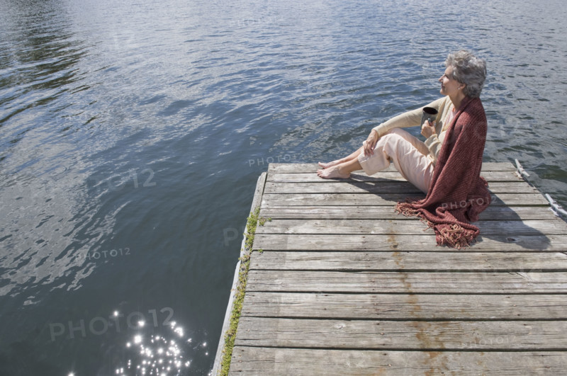 Senior woman sitting on dock.