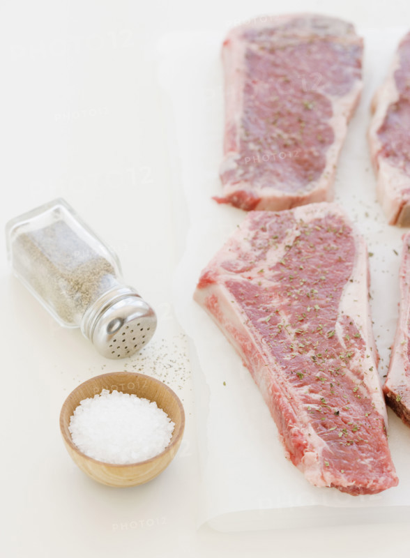Close up of raw steaks and seasoning. Date : 2008