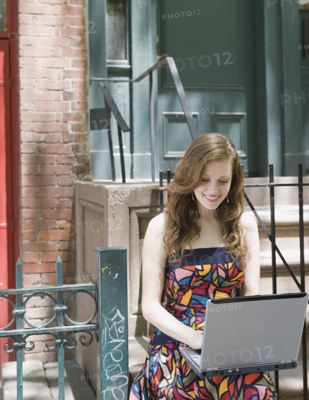 Young woman using laptop in urban setting. Date : 2008