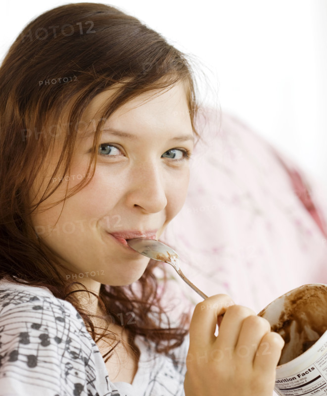 Teenage girl eating from ice cream carton. Date : 2008