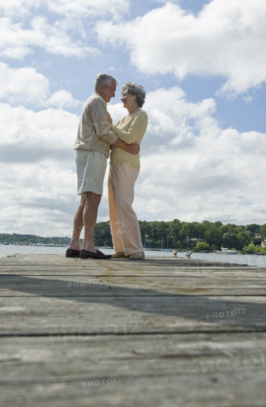 Senior couple hugging on dock.
