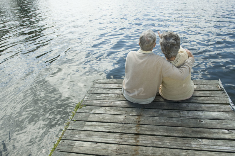 Senior couple hugging on dock.