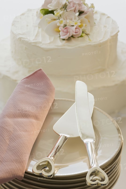 Wedding cake and stack of plates.
