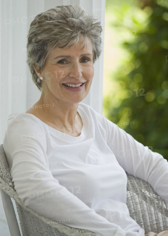 Senior woman sitting on porch.