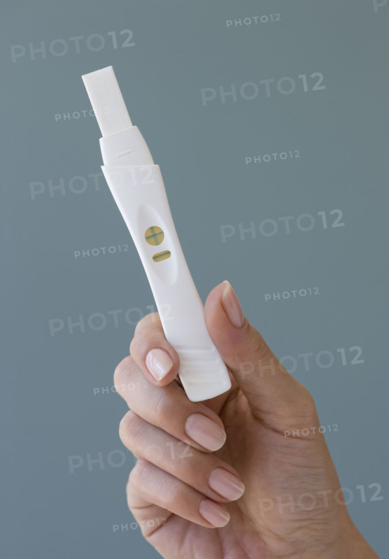 Close up of woman holding pregnancy test.