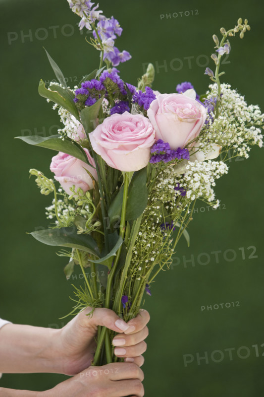Woman holding bouquet of flowers.