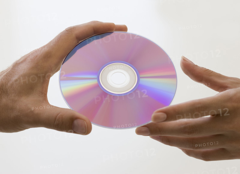 Close up of hands and compact disc.