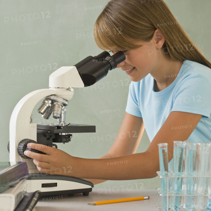 Girl using microscope.
