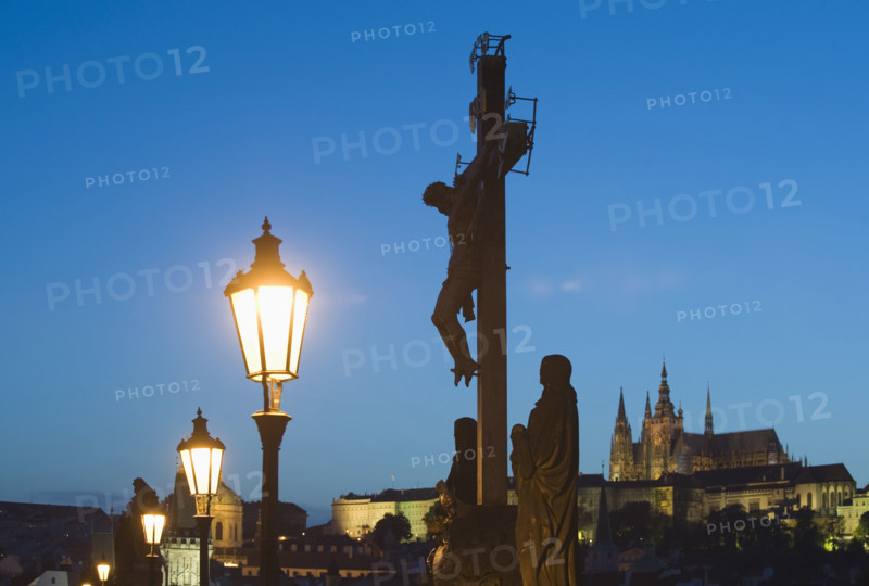 Night view of crucifix and cathedral.