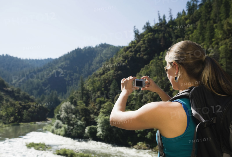 Hiker photographing river scene. Date : 2008